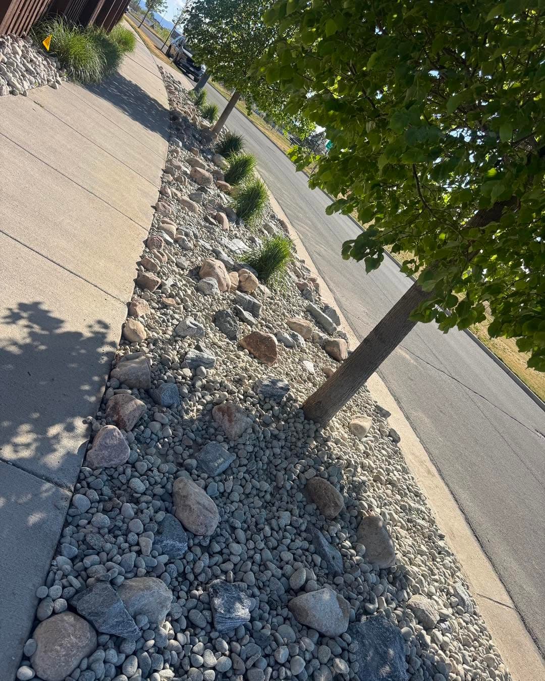 Decorative river stones with ornamental grass and white accent rocks
