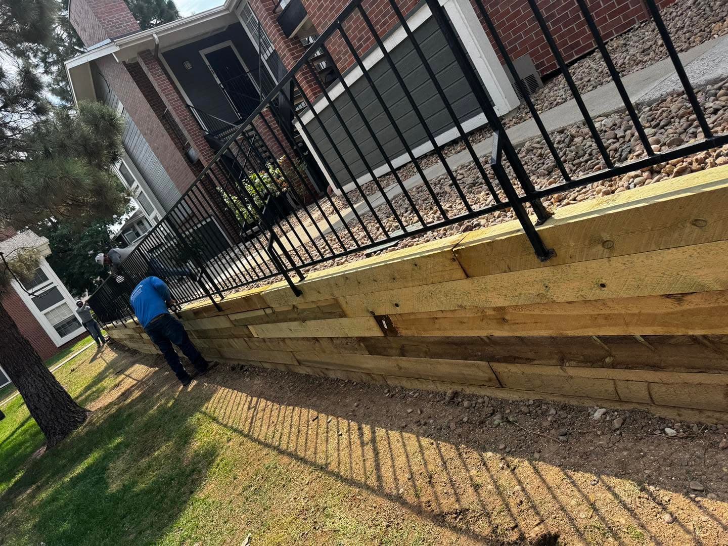 Crew member installing a wooden retaining wall