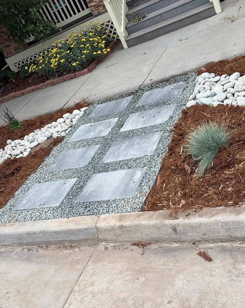 Concrete stepping stones in geometric pattern with gravel and river rocks